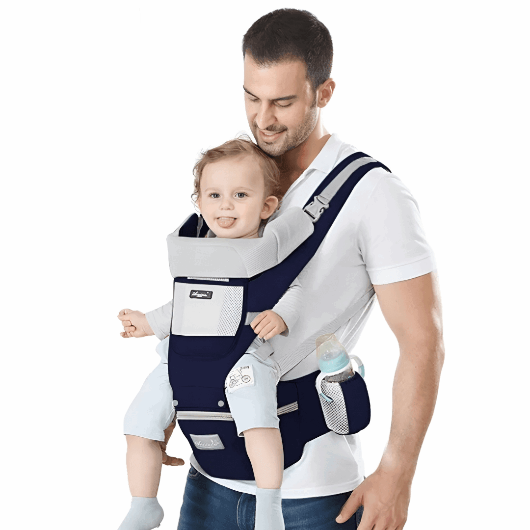 baby in a baby carrier with a man standing - un homme porte son bébé avec un porte-bébé bleu marine