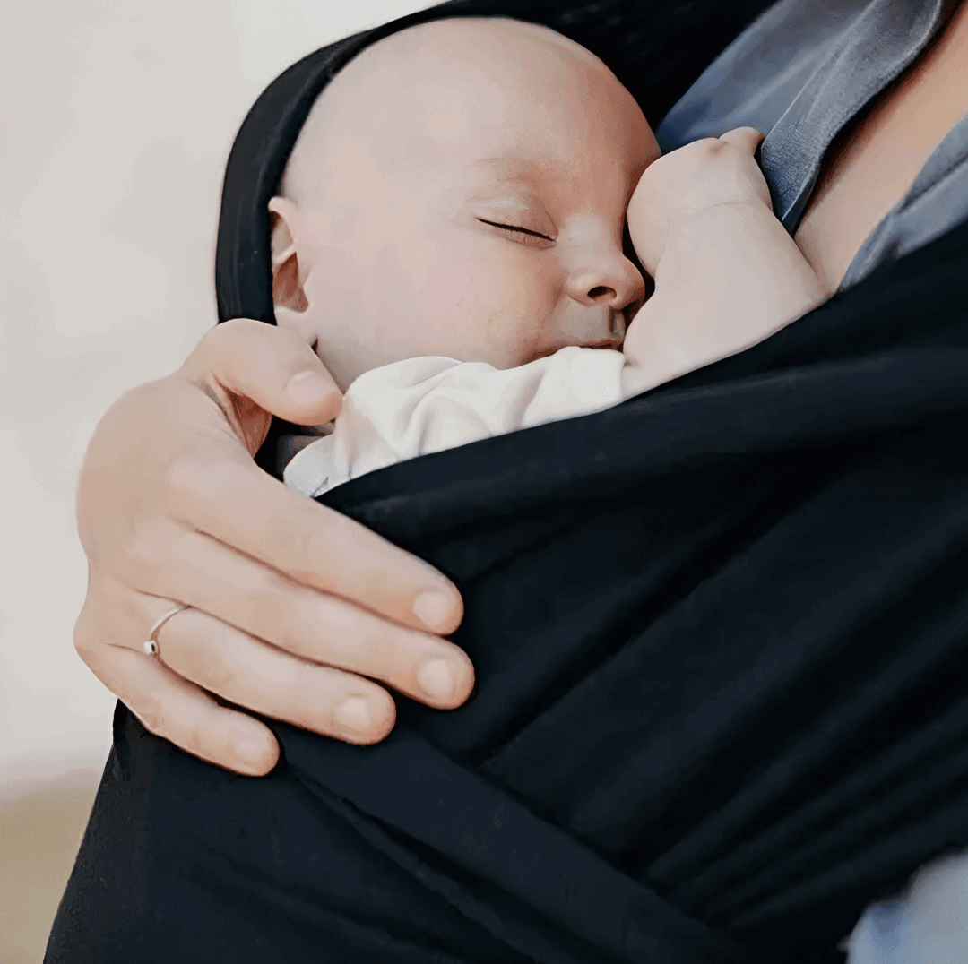 woman with a baby in a black baby wrap carrier - un bébé dans un écharpe pour bébé noir et une femme - VLF Shop