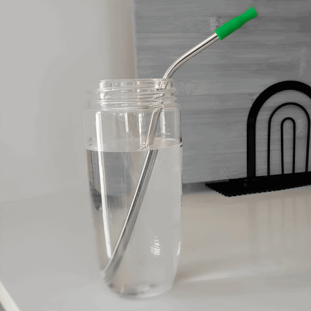 stanless steel straw with green tips in a bottle - une pailles réutilsable en acier inoxydable dans un verre